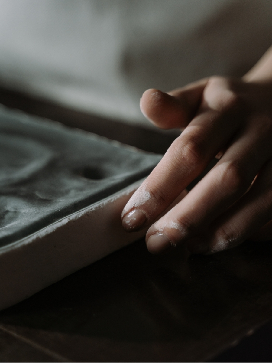 Hands shaping a piece of clay by hand