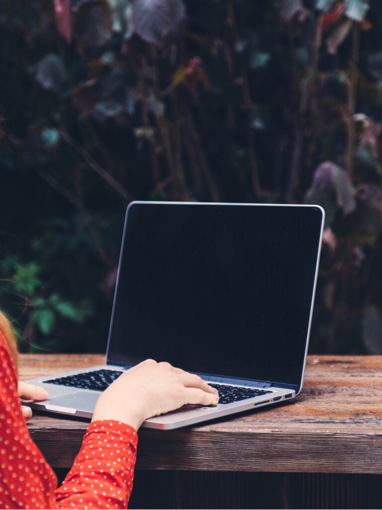 Person working on a laptop at an outdoor table